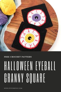 two crocheted halloween eyeball granny square on top of a wooden table with yarn balls