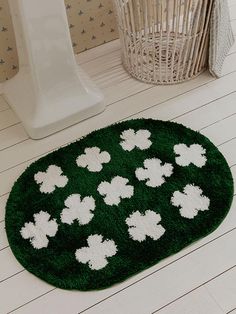 a green rug with white shamrocks on it in a bathroom next to a toilet