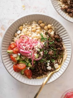 two bowls filled with rice, meat and veggies on top of a table