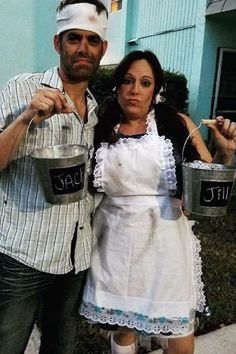 a man and woman dressed in costumes holding buckets with chalk written on them while standing next to each other