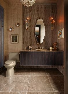 a bathroom with a white toilet sitting next to a sink and a mirror on the wall