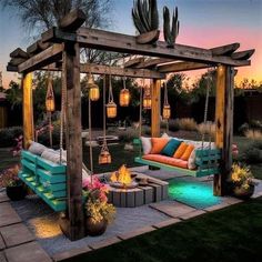 an outdoor seating area is lit up at night with hanging lights and cactus plants on the side