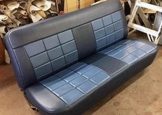 a blue leather couch sitting in a warehouse