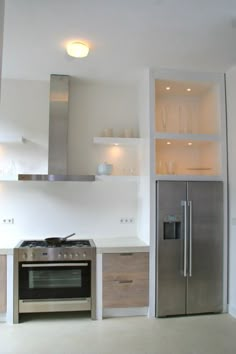 a kitchen with stainless steel appliances and white walls