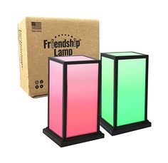 three different colored candles sitting next to each other in front of a box with the packaging on it