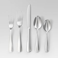 an assortment of silverware including forks, knives and spoons on a white surface