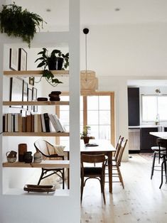 a room filled with furniture and lots of bookshelves next to a dining table