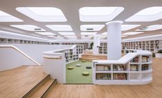 the interior of a library with bookshelves and stairs leading up to two levels