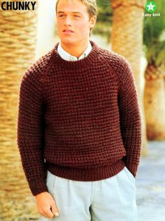 a man in a sweater and pants standing next to palm trees