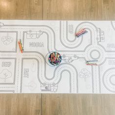 two crayons are sitting on top of a paper map with cars and roads