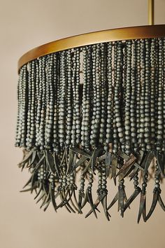 a chandelier hanging from a ceiling with beads and birds on the bead