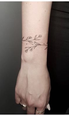 a woman's hand with a small tattoo on the wrist and an arrow in the middle