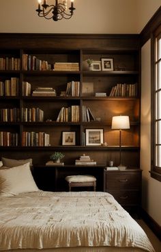 a bed sitting in front of a book shelf filled with books