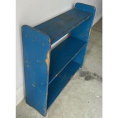 an old blue book shelf sitting against a wall