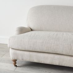 a white couch sitting on top of a hard wood floor