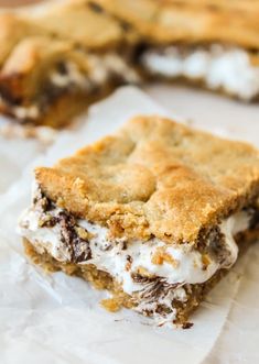 an ice cream sandwich is cut in half and sitting on wax paper next to the cookie