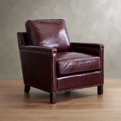 a brown leather chair sitting on top of a wooden floor