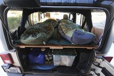 the back end of a van filled with sleeping bags