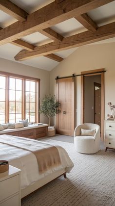 a bedroom with a large bed and wooden beams on the ceiling, along with white furniture