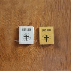 two small bibles sitting on top of a wooden table