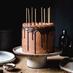 there is a chocolate cake on the table with some candles sticking out of it's top