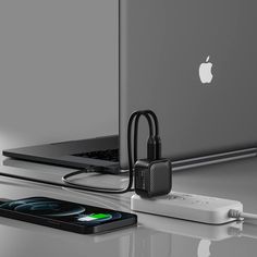 an apple laptop computer sitting on top of a desk next to a charger and usb cable