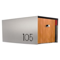 an aluminum mailbox with wooden door and numbers on the front, shown from the side