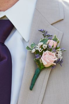 a man wearing a suit and tie with a boutonniere on his lapel