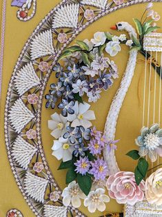 a close up of a string instrument decorated with flowers and leaves on a yellow background