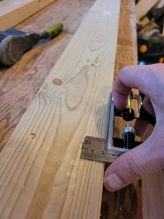 a person is measuring the width of a piece of wood