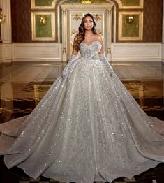 a woman in a wedding dress with long sleeves and sequins on the skirt