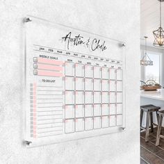 a calendar hanging on the wall next to stools and a kitchen table with chairs