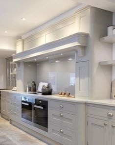 a large kitchen with white cabinets and an oven