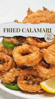 fried calamari on a plate with lemon wedges