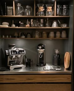 a coffee maker is on the counter in front of shelves filled with pots and pans