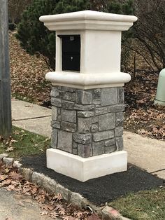 a stone mailbox sitting on the side of a road