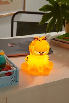 a yellow tiger lamp sitting on top of a desk next to a plant and other items