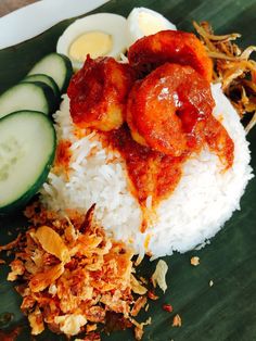 a plate with rice, cucumber and eggs on it next to other food items