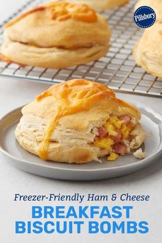 there is a breakfast biscuit with ham and cheese on the plate next to it