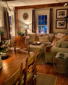 a living room filled with furniture next to a wooden table covered in potted plants