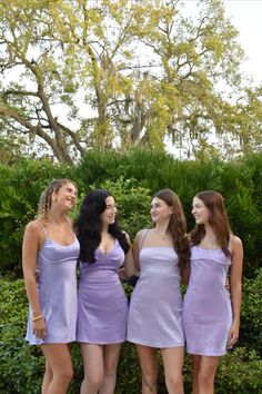 three women in purple dresses standing next to each other