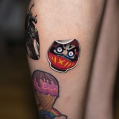 a close up of a person's leg with tattoos on it and an ice cream cone