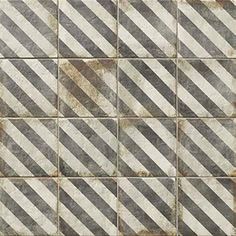 an old tile wall with diagonal stripes in grey and white