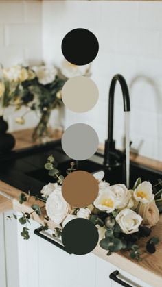 a kitchen counter with flowers and black faucet