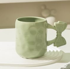 a green coffee mug sitting on top of a table