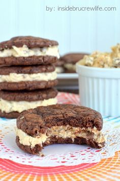 some cookies are stacked on top of each other and one is cut in half to show the cream filling