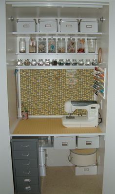 a sewing machine sitting on top of a wooden table in front of a shelf filled with bins