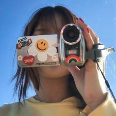 a woman holding up a camera to her face