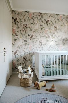 a baby's room with a crib and wallpaper