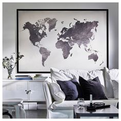 a living room filled with furniture and a map on the wall